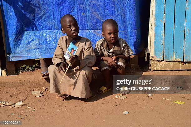 Children wait to see Pope Francis convoy on November 30, 2015 in a street of Bangui during a papal visit to Africa. Pope Francis arrived as "a...