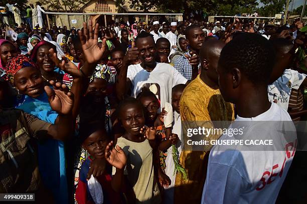 People wait to see Pope Francis convoy on November 30, 2015 in a street of Bangui during a papal visit to Africa. Pope Francis arrived as "a pilgrim...