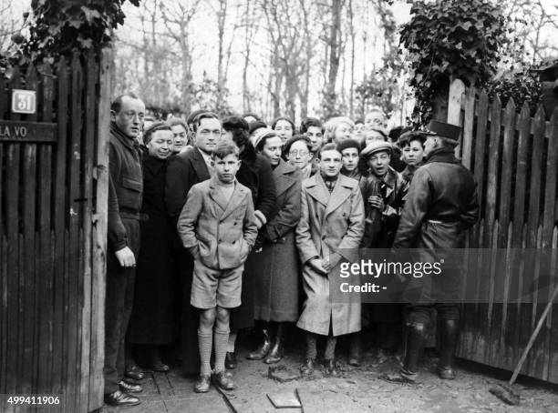 Photo reçue le 11 décembre 1937 de badauds assistant à la perquisition de la villa "La Voulzie" à La Celle-Saint-Cloud louée par le criminel Allemand...