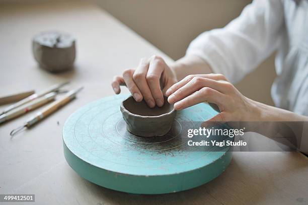 female potter shaping the vessel manually - pottery making stock-fotos und bilder