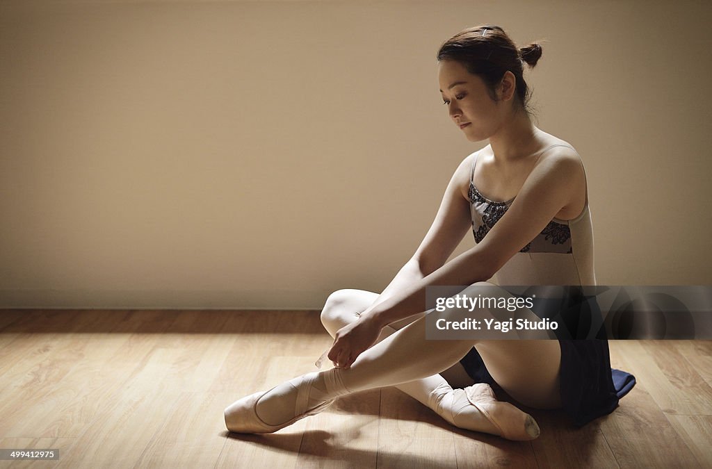 Ballerina adjusting shoes.