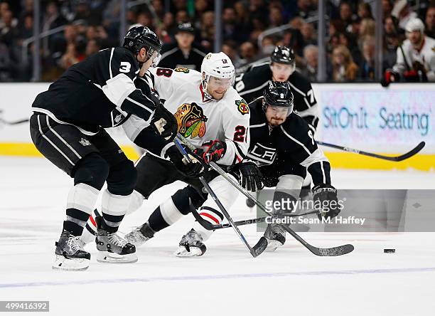 Brayden McNabb of the Los Angeles Kings, Drew Doughty of the Los Angeles Kings, battle Ryan Garbutt of the Chicago Blackhawks for a loose puck during...
