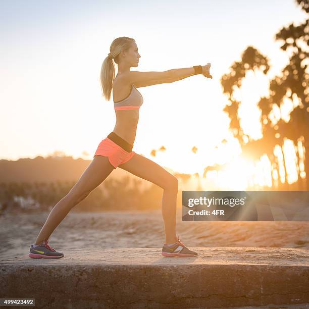 athletic woman stretching at the beach at sunset - venice california stock pictures, royalty-free photos & images