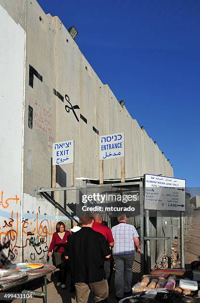 bethlehem-west bank: menschen überqueren sie die grenze, israelischen wall - bethlehem west bank stock-fotos und bilder