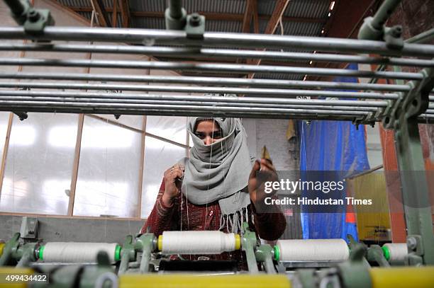 Kashmiri Muslim woman labourer works inside a silk factory on the outskirts of Srinagar, on December 1, 2015 in Srinagar, India. Kashmir, once famous...