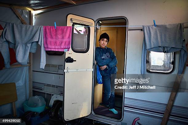 Boy looks out a camper van as migrants contend with wintery conditions in the camp known as the 'New Jungle' on December 1, 2015 in Calais, France....