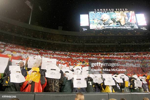 Fans in the stands hold up red white and blue during was colors during the playing of the National Anthem before the game between the Chicago Bears...