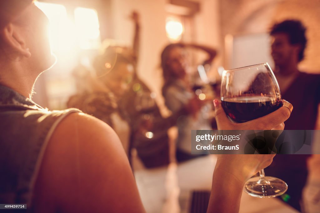 Close up of woman enjoying in wine at office party.