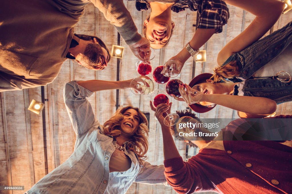 Abaixo de vista de jovens feliz de amigos de torrar vinho.