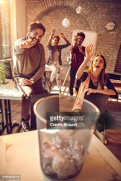 playful business team tossing crumpled papers into the wastepaper basket. - throwing rubbish stock pictures, royalty-free photos & images