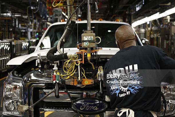 Worker wearing a United Auto Workers shirt assembles a Ford Motor Co. Super Duty series pickup truck at the company's truck manufacturing plant in...