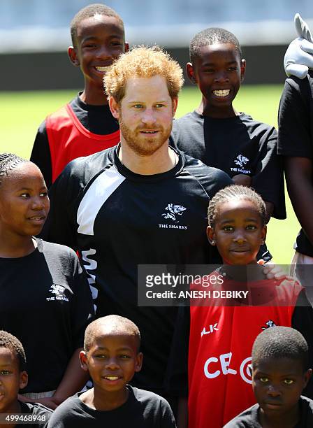 Britain's Prince Harryposes with chldren as he visits the staff and management at the GrowthPoint Kings Park Stadium on December 1, 2015 in Durban....