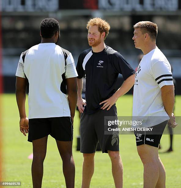 Britain's Prince Harry speaks to members of the staff during a visit to the staff and management at the GrowthPoint Kings Park Stadium on December 1,...