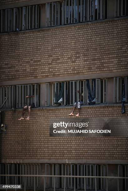 Inmates sit on the window of their cell in the Kgosi Mampuru II Prison where Oscar Pistorius spent part of his sentence, on December 1, 2015 in...