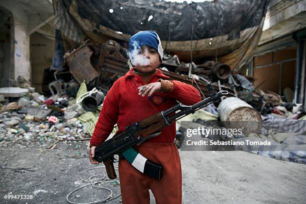 Ahmed, the 8-year-old son of a Free Syrian Army fighter, stands in front of a barricade were he assists Free Syrian Army fighters in the neighborhood...