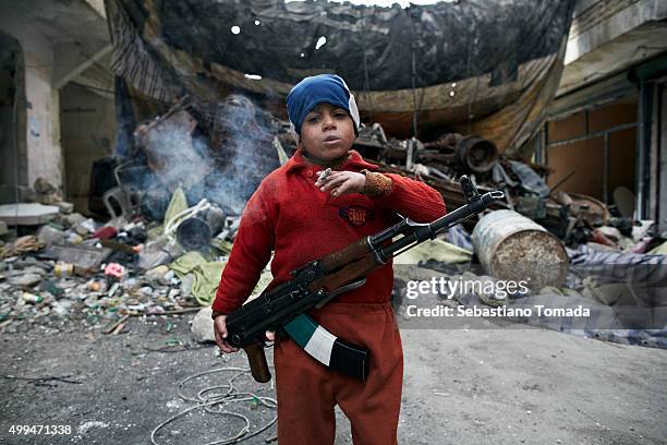 Ahmed, the 8-year-old son of a Free Syrian Army fighter, stands in front of a barricade were he assists Free Syrian Army fighters in the neighborhood...