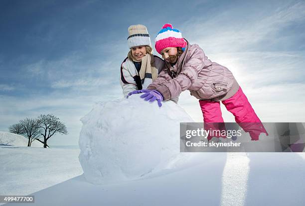 irmão e irmã de rolamento para com bolas de neve boneco de neve. - bola de neve imagens e fotografias de stock