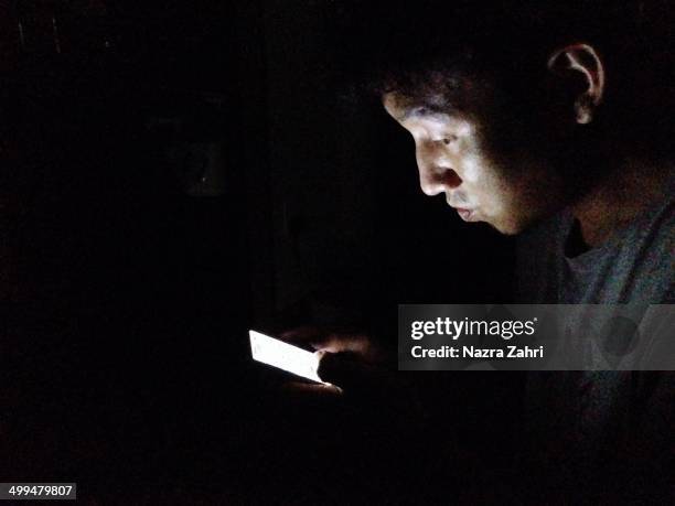 Playing a smartphone game in the dark.