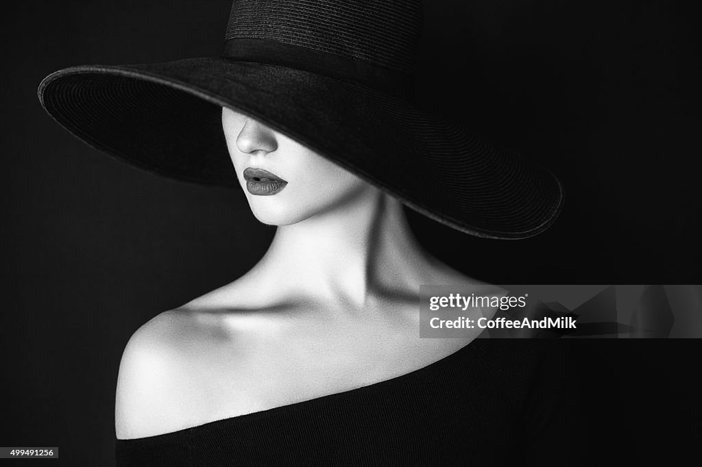 Studio shot of young beautiful woman wearing hat