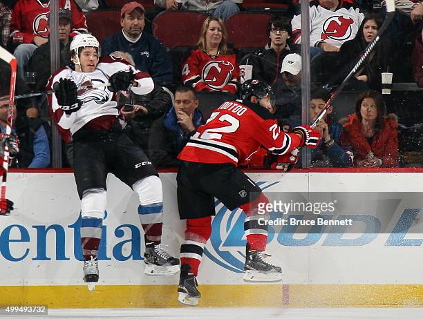 Zach Redmond of the Colorado Avalanche is hit by Jordin Tootoo of the New Jersey Devils during the first period at the Prudential Center on December...