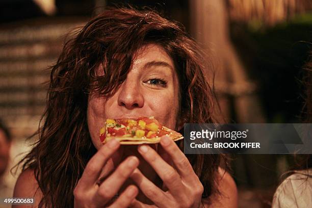 young woman eating food at bar - hungry foto e immagini stock