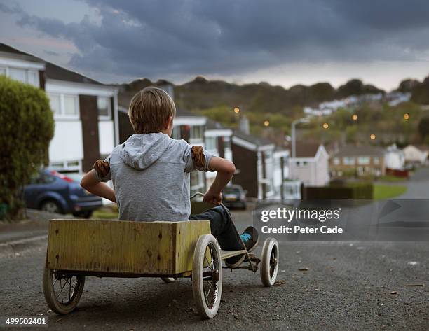 boy in homemade go kart at top of street - go cart stock pictures, royalty-free photos & images