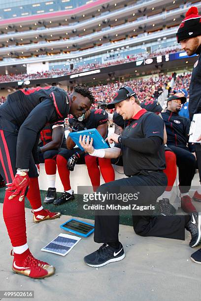Eli Harold and Linebackers Coach Jason Tarver of the San Francisco 49ers talk on the sideline during the game against the Arizona Cardinals at Levi...