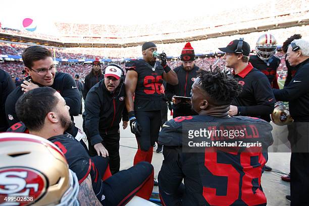 Head Coach Jim Tomsula and Linebackers Coach Jason Tarver of the San Francisco 49ers talk with members of the defense on the sideline during the game...