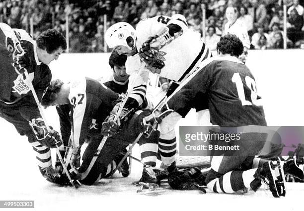 Grant Mulvey of the Chicago Blackhawks battles for the puck with Errol Thompson, Darryl Sittler, Ian Turnbull and Jim McKenny of the Toronto Maple...