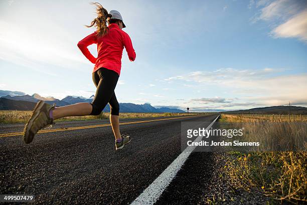 a woman jogging - running shoes sky stock-fotos und bilder