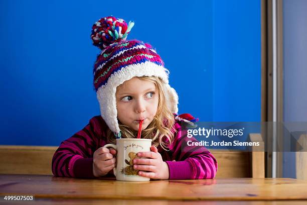 young girl drinking hot chocolate - bonnet à pompon photos et images de collection