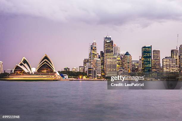 sydney cbd and harbor illuminated at dusk - sydney skyline stock pictures, royalty-free photos & images