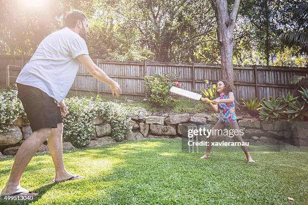 father and daughter playing cricket in the garden - cricket player stockfoto's en -beelden