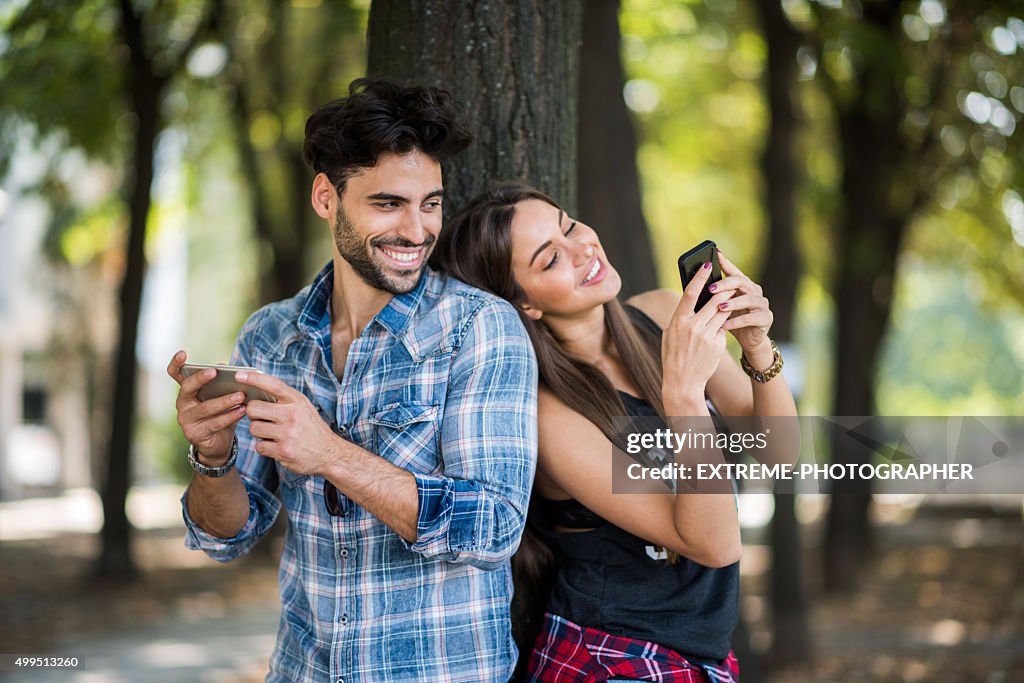 Casal no Parque utilização de dispositivos móveis