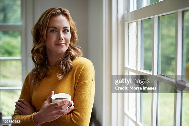 confident woman having coffee in cottage - cup portraits foto e immagini stock