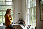 Thoughtful woman having coffee in cottage
