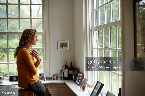 thoughtful woman having coffee in cottage - woman reflection window stock pictures, royalty-free photos & images