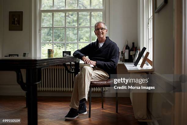 portrait of senior man sitting in cottage - sedersi posizione fisica foto e immagini stock