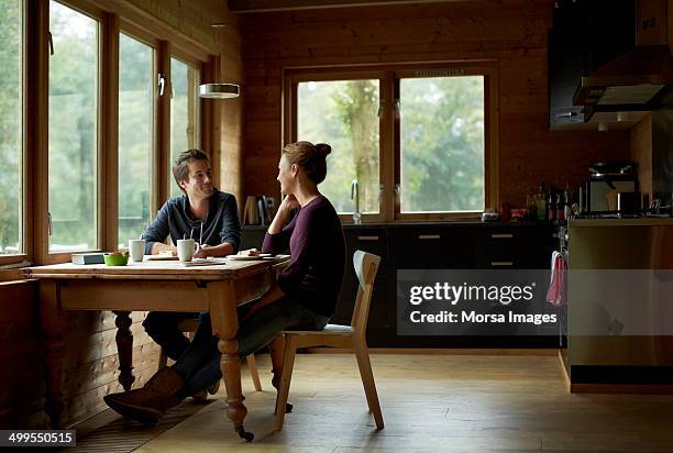 couple having breakfast at table in cottage - sedersi posizione fisica foto e immagini stock