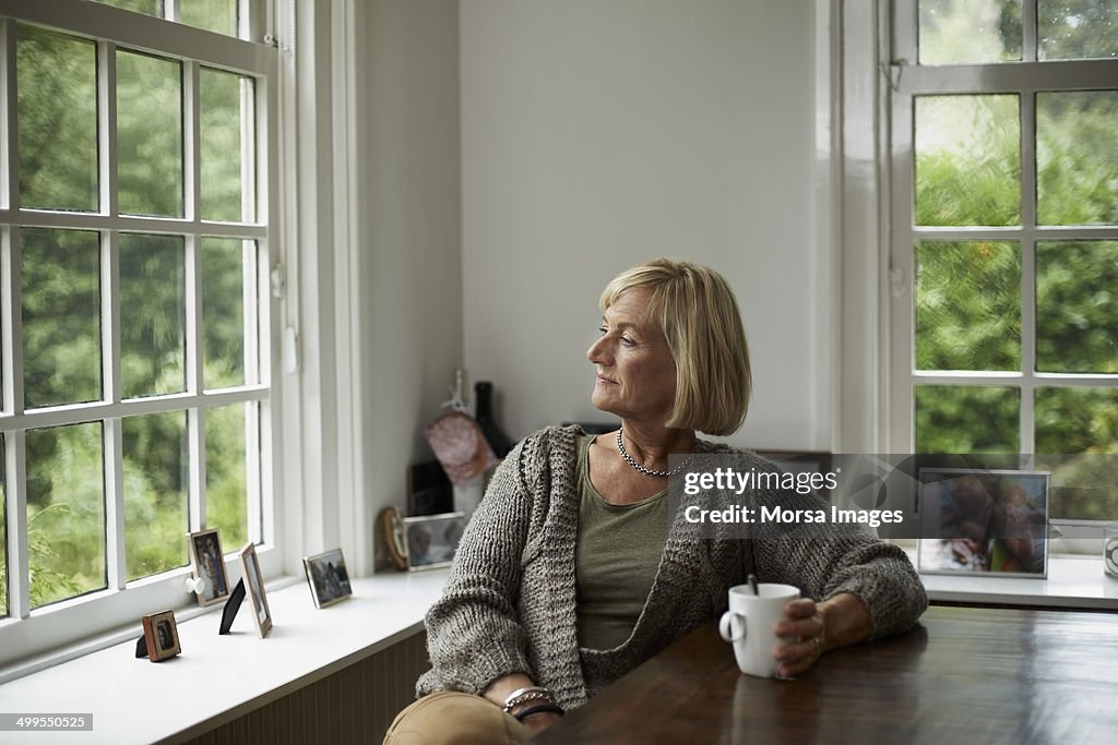 Thoughtful senior woman having coffee