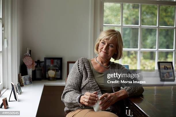 thoughtful senior woman in cottage - womens indoor cup 2013 stock pictures, royalty-free photos & images