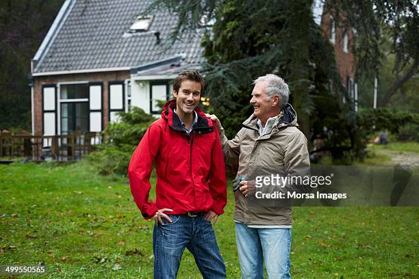 happy man with father outside cottage - two houses side by side stock pictures, royalty-free photos & images