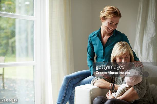 happy family of three generations on sofa - grootouder stockfoto's en -beelden