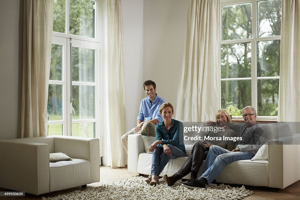 Happy family sitting on sofa in country house