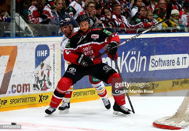 Alexander Sulzer of Koelner Haie and Norm Milley of Duesseldorfer EG battle for the puck during the DEL Ice Hockey match between Koelner Haie and...