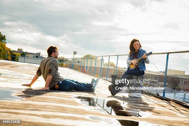 young woman sings her new country song to male friend - country and western music stock pictures, royalty-free photos & images