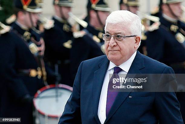 Iraq's President Fuad Masum reviews French troops prior to attend a meeting with French President Francois Hollande at the Elysee Presidential Palace...