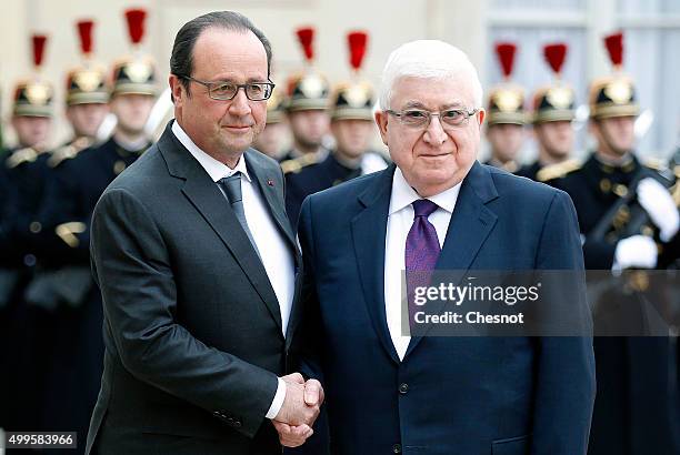 French President Francois Hollande welcomes Iraq's President Fuad Masum prior to attend a meeting at the Elysee Presidential Palace on December 02,...
