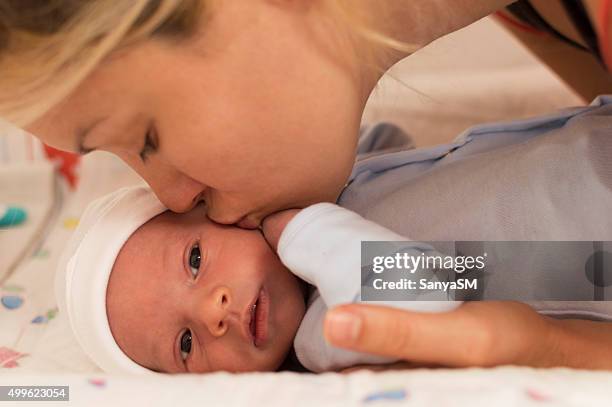 mother kissing newborn baby boy - beautiful blonde babes stock pictures, royalty-free photos & images