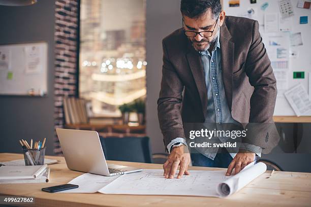 hombre trabajando en oficina moderna espacio. - design occupation fotografías e imágenes de stock